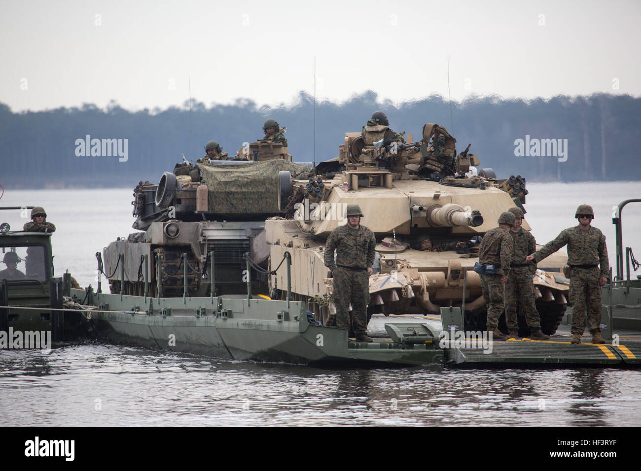 U.S. Marines with 2d Tank Battalion, 2d Marine Division (2D MARDIV), and 2d Assault Amphibian Battalion, 2D MARDIV, transport M1A1 Abrams tanks across a river with a seven bay raft system during the Iron Blitz field training exercise on Camp Lejeune, N.C., Feb. 22, 2016. The exercise was conducted increase the Marines proficiency in both offensive and defensive operations on unfamiliar terrain. (U.S. Marine Corps photo by Lance Cpl. Abraham Lopez, 2D MARDIV Combat Camera/Released) Iron Blitz Field Exercise 160222-M-MN519-166 Stock Photo