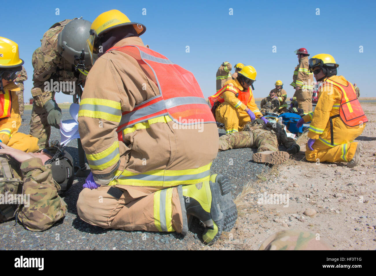 Paramedics of the George Washington University Emergency Medical Services and firefighters from Vectrus Fire and Emergency Services treat simulated patients from the Army National Guard 40th Combat Aviation Brigade during a pre-accident plan exercise at Camp Buehring, Kuwait, Feb. 24. A pre-accident plan prepares military and civilian agencies to work together in the event of an emergency situation. (U.S. Army Photo by Staff Sgt. Ian M. Kummer, 40th Combat Aviation Brigade Public Affairs) 40th CAB executes pre-accident plan 160224-Z-JK353-001 Stock Photo