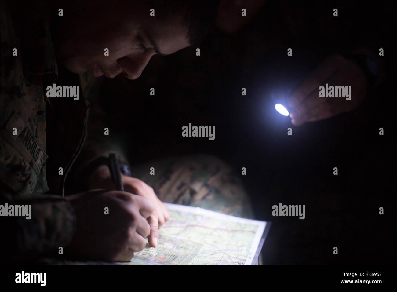 A U.S. Marine from the School of Infantry-East, plots points on a map during the night land navigation portion of the Combat Instructor Stakes on Camp Lejeune, N.C., March 16, 2015. The School of Infantry-East hosted the Combat Instructor Stakes, which is a grueling 30-hour competition that pits two man teams against each other, competing in physical, tactical and knowledge based events while carrying a combat load and moving over 50 kilometers on foot. (U.S. Marine Corps photo by SOI-East Combat Camera, Cpl. Andrew Kuppers/ Released) CI Stakes 2016 160316-M-NT768-013 Stock Photo