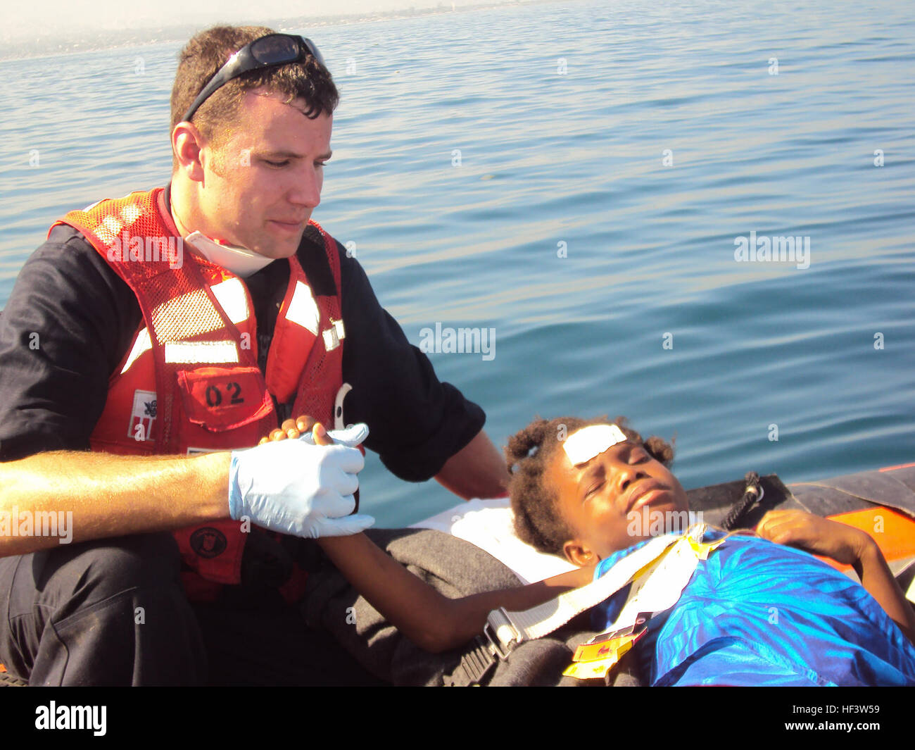 A Coast Guard crewmember aboard the Cutter Tahoma provides medical aid ...