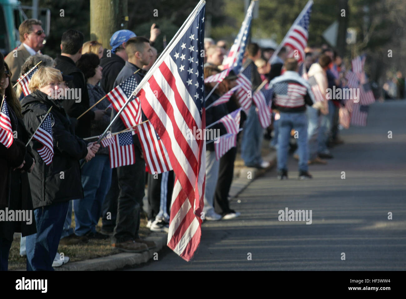 People line the street to honor a local Marine killed in Afghanistan, Jan. 21. The body of Sgt. Christopher R. Hrbek, 25, a Westwood, N.J., native, was escorted from Dover Air Force Base, Del., past streets lined with people waving American Flags to Beckers Funeral Home. Hrbek, a field artillery cannoneer with 3rd Battalion, 10th Marine Regiment, Regimental Combat Team 7, II Marine Expeditionary Force, died Jan. 14 while conducting combat operations in Helmand Province, Afghanistan. He is scheduled to be awarded a Bronze Star Medal with combat distinguishing device Jan. 23 at his funeral. The  Stock Photo