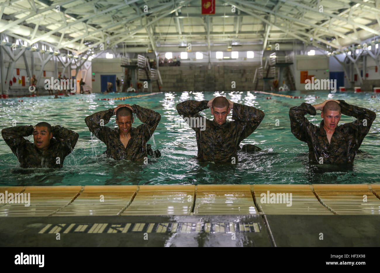 Recruits of Lima Company, 3rd Recruit Training Battalion, hold their hands about their heads after finishing the 10-second gear strip during the Water Survival Basic Qualification at Marine Corps Recruit Depot San Diego, April 11. This qualification will be valid for the recruits for two years. Depending on their military occupational specialty, they may go through higher qualification levels. Annually, more than 17,000 males recruited from the Western Recruiting Region are trained at MCRD San Diego. Lima Company is scheduled to graduate June 10. Co. L - Swim Qualification 160411-M-WQ808-031 Stock Photo