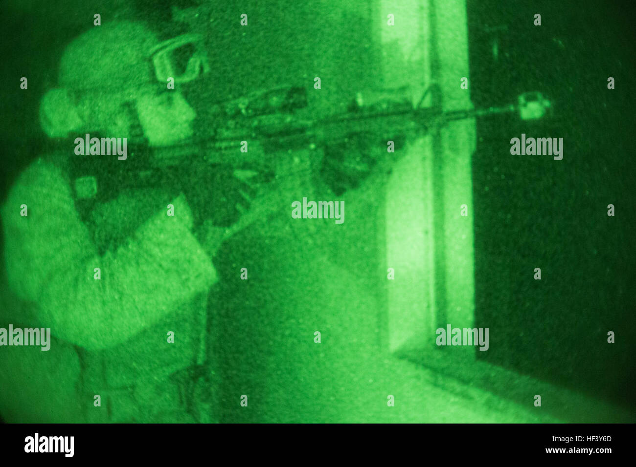 A Marine fires at a simulated hostile enemy from a building seized moments earlier during a night raid training evolution aboard Marine Corps Base Camp Pendleton, Calif., April 28, 2016. The Marines are refining their raid capabilities, which include clearing enemy-occupied buildings, establishing control points for friendly and enemy casualties, retrieving high-value targets and weapons caches, and evacuating the area in a short, controlled time-limit. The Marines are with the Light Armored Reconnaissance company of Battalion Landing Team, 1st Bn., 4th Marines, 11th Marine Expeditionary Unit. Stock Photo