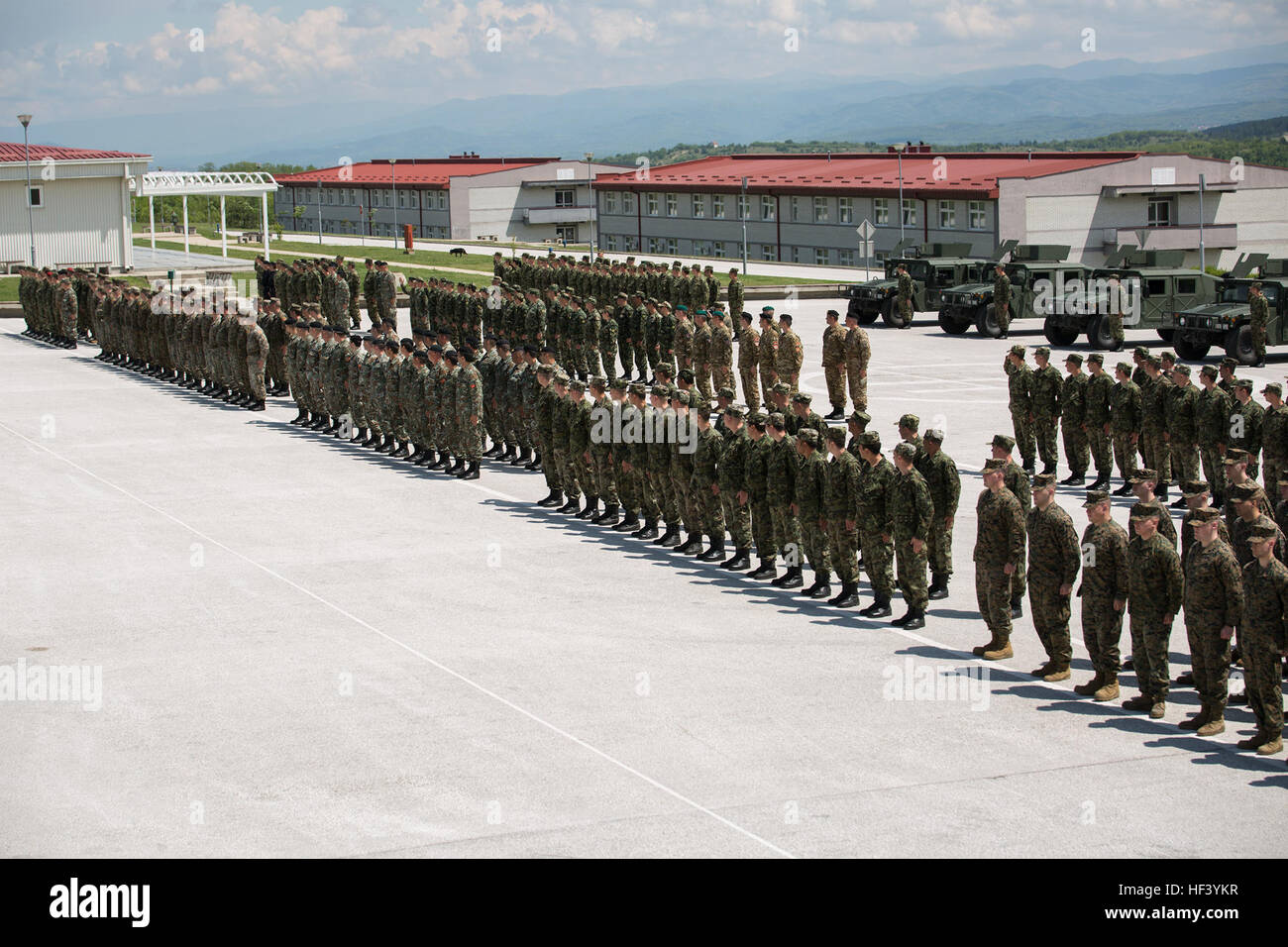 Service members from Bosnia, Bulgaria, Macedonia, Montenegro, Slovenia, Serbia and the United States stand in formation during the opening ceremony of Platinum Wolf 2016 at the Peacekeeping  Operations Training Center South Base in  Bujanovac, Serbia, May 9, 2016. Reserve Marines from 4th Law Enforcement Battalion, Force Headquarters Group, Marine Forces Reserve, and 3rd Civil Affairs Group, FHG, MARFORRES, are joining the partner nations to participate in the peacekeeping operations training exercise focused on non-lethal systems. (U.S. Marine Corps photo by Sgt. Sara Graham) Platinum Wolf 20 Stock Photo