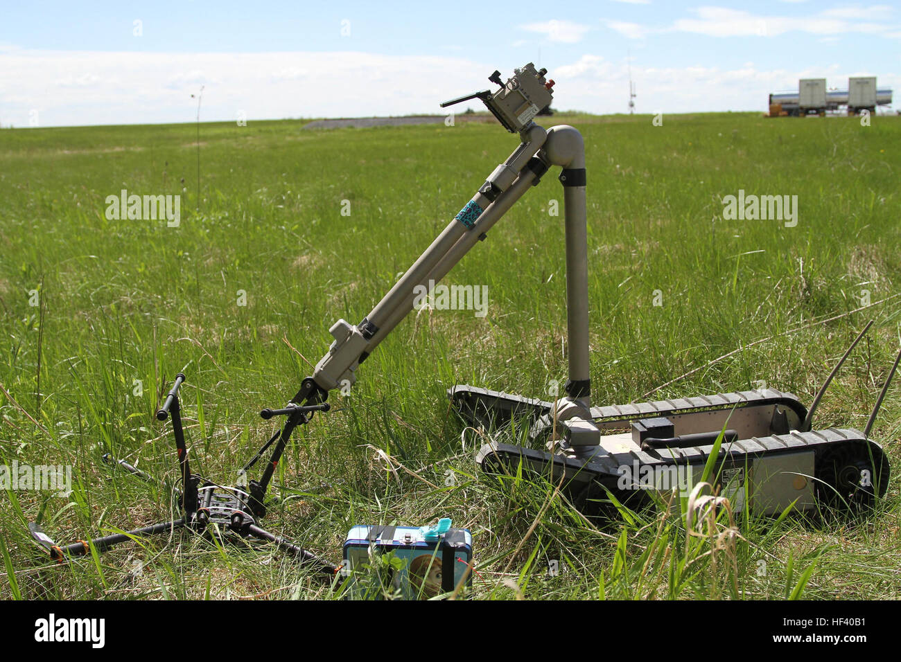 A bomb disposal robot, piloted from a distance, examines a downed drone