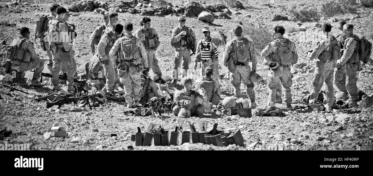 A U.S. Marine with Tactical Training Exercise Control Group, debriefs Marines with Kilo Company, 3rd Battalion, 2nd Marines at Marine Corps Air Ground Combat Center Twentynine Palms, Calif., May 25, 2016. The control group Marine briefed the Marines on their performance during the company's live-fire range. (U.S. Marine Corps photo illustration by Staff Sgt. Gabriela Garcia/Released) CMC at 29 Palms 160525-M-SA716-145 Stock Photo