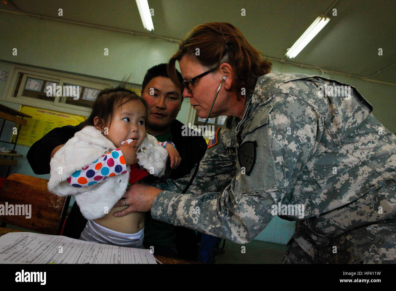 U.S. Army Col. Rebecca Young, a nurse practitioner and commander of the Medical Detachment, assigned to Alaska National Guard, uses a stethoscope to examine a child while providing medical care at the Khaan Quest 2016 Health Services Support Engagement event at a local school in Ulaanbaatar, Mongolia, May 26, 2016. Khaan Quest 2016 is an annual, multinational peacekeeping operations exercise hosted by the Mongolian Armed Forces, co-sponsored by U.S. Pacific Command, and supported by U.S. Army Pacific and U.S. Marine Corps Forces, Pacific. Khaan Quest, in its 14th iteration, is the capstone exe Stock Photo
