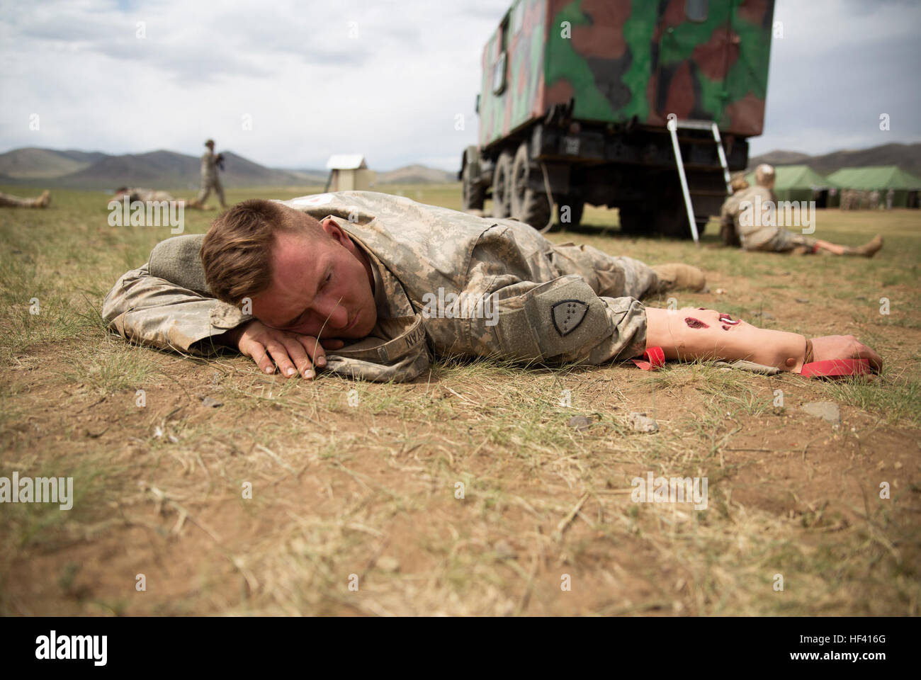 Army Sgt. Corey Bryan volunteers to pose as a simulated casualty in a practical application exercise in the combat medical care lane of Khaan Quest 2016 at Five Hills Training Area near Ulaanbaatar, Mongolia, May 30. The training equipped soldiers with essential life-saving skills and the ability to prioritize injuries and medical care. Khaan Quest 2016 is an annual, multinational peacekeeping operations exercise hosted by the Mongolian Armed Forces, co-sponsored by U.S. Pacific Command, and supported by U.S. Army Pacific and U.S. Marine Corps Forces, Pacific. Khaan Quest, in its 14th iteratio Stock Photo