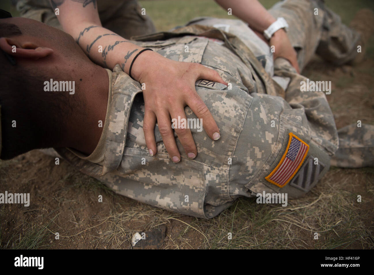 A U.S. Soldier with the Alaska Army National Guard places on a simulated casualty’s wound in a practical application exercise in the combat medical care lane of Khaan Quest 2016 at Five Hills Training Area near Ulaanbaatar, Mongolia May 30. The training equipped soldiers with essential life-saving skills and the ability to prioritize injuries and medical care. Khaan Quest 2016 is an annual, multinational peacekeeping operations exercise hosted by the Mongolian Armed Forces, co-sponsored by U.S. Pacific Command, and supported by U.S. Army Pacific and U.S. Marine Corps Forces, Pacific. Khaan Que Stock Photo