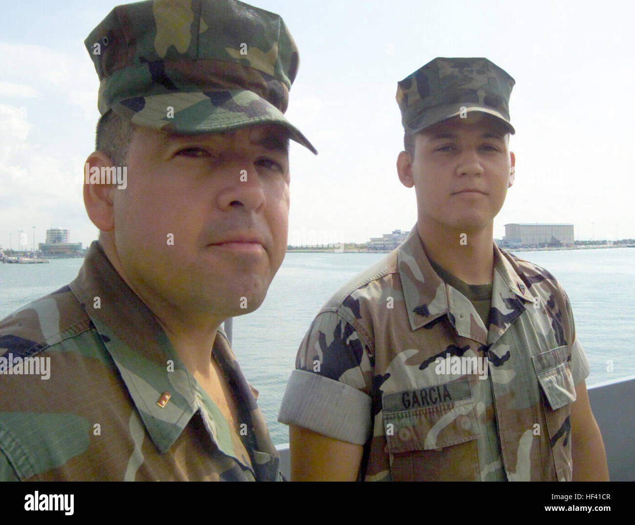 020722-M-2706G-018 Aboard USS Denver (LPD-9) inport Singapore (Jul. 22, 2002) -- Chief Warrant Officer Armando Garcia and his son, Cpl. Armando Garcia, stand on the flight deck of USS Denver.  Both father and son are deployed to the Western Pacific with the U.S. MarinesÕ Battalion Landing Team 3/1, 11th Marine Expeditionary Unit (MEU) Special Operations Capable (SOC) to the Western Pacific conducting missions in support of Operation Enduring Freedom.  U.S. Marine Corps photo.  (RELEASED) US Navy 020722-M-2706G-018 Father 5E Son reunite in Singapore Stock Photo