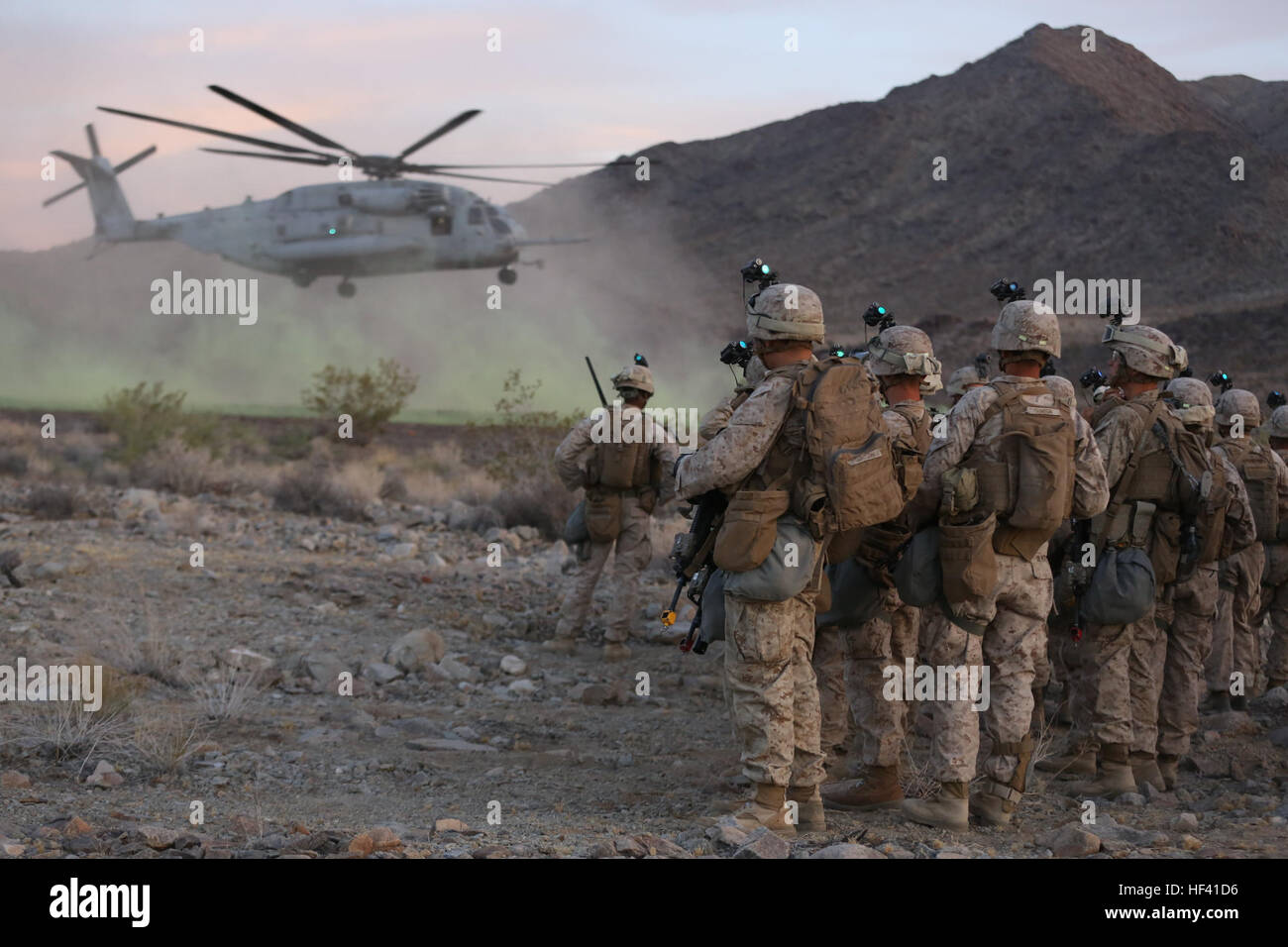 Marines of Company K, 3rd Battalion, 7th Marine Regiment, 1st Marine Division wait to board a CH-53E Super Stallion prior to a night raid aboard Marine Corps Air Ground Combat Center Twentynine Palms, Calif., June 6, 2016. The Marines utilized air support for air insertion and to provide air strikes on enemy targets throughout the battalion’s Marine Corps Combat Readiness Evaluation. (U.S. Marine Corps photo by Lance Cpl. Timothy Valero/ Released) 3rd Battalion 7th Marines prepare for deployment 160606-M-HF454-032 Stock Photo