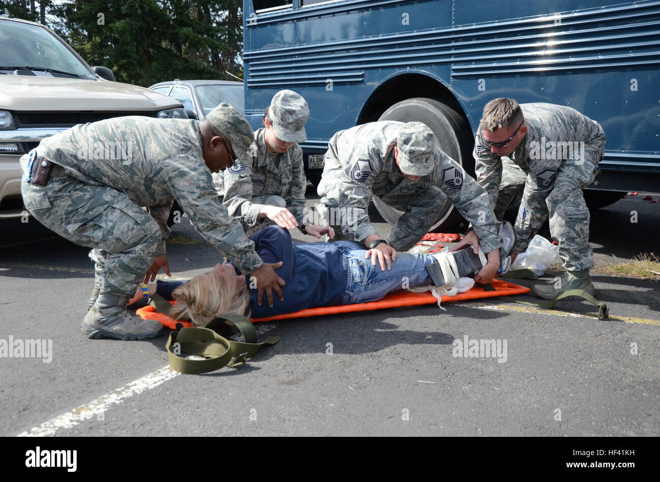 Medics with the 194th Medical Group move a role playing victim onto a liter carrier for transportation to a treatment facility as part of a massive casualty care exercise at Joint Base Lewis-McChord on June 8, 2016 as part of Cascadia Rising. The casualty care exercise simulated the collapse of an overpass along Interstate 5 onto a bus resulting in multiple injured. Upon arrival airmen with the 194th Medical Group worked quickly to triage patients before transporting them to a simulated medical treatment facility. (U.S. Army National Guard photo by SPC Brianne Kim) Air Guardsmen respond to sim Stock Photo