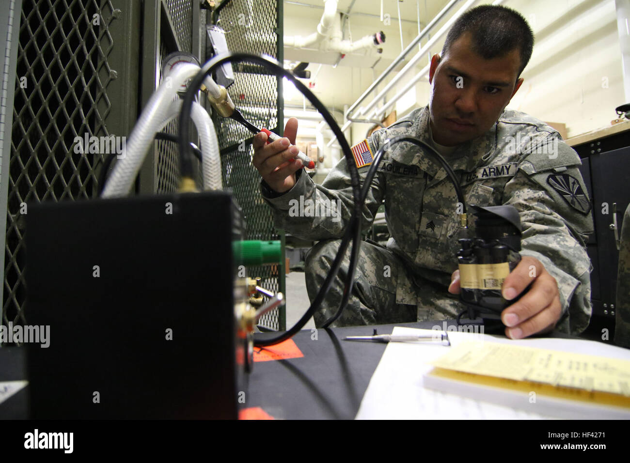 Arizona Army National Guard Sgt. Armono A. Aguilera, a computer/detection systems repairer with the 3666th Support Maintenance Company, purges air from a PVS-14 night vision monocular during an inspection, June 22, at Fort Greely, Alaska, which is located approximately 100 miles southeast of Fairbanks, Alaska. Aguilera was part of a mobile repair team that came to Alaska during the 3666th’s 15-day annual training to inspected weapons and night vision optics for the Alaska National Guard’s 49th Missile Defense Battalion. (Arizona Army National Guard photo by Staff Sgt. Brian A. Barbour) 3666th  Stock Photo