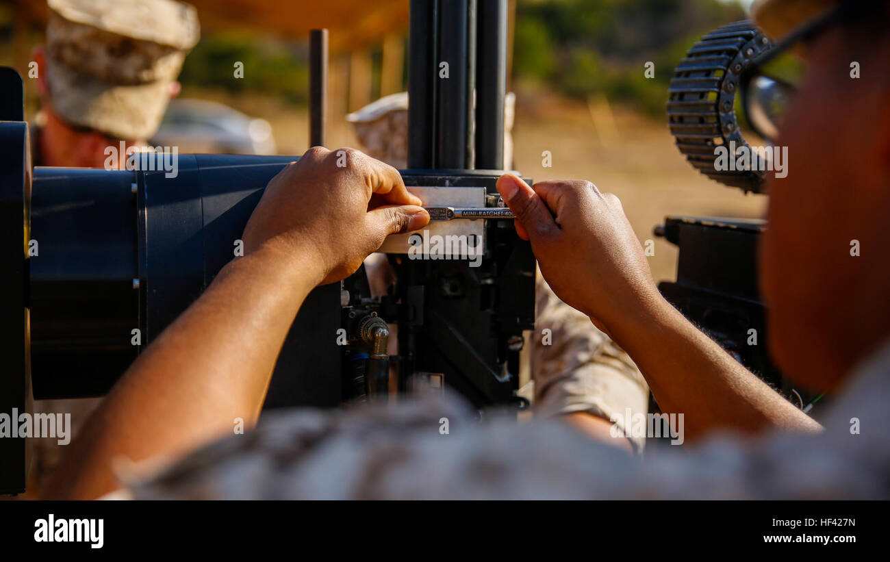 Lance Cpl.  Jorge Sainz, a rifleman with Kilo Company, 3rd Battalion, 5th Regiment, attaches the M134 Minigun to the Robotic Vehicle Modular system aboard Camp Pendleton, June 23, 2016. The Marines were learning how to operate the system which is going to be tested during Rim of the Pacific 2016 with partner nations. The RVM is designed to assist an infantry platoon by providing more fire power, bearing equipment loads and designating targets for air assaults. The Marine Corps Warfighting Laboratory is conducting a Marine Air-Ground Task Force Integrated Experiment to explore new gear and acce Stock Photo