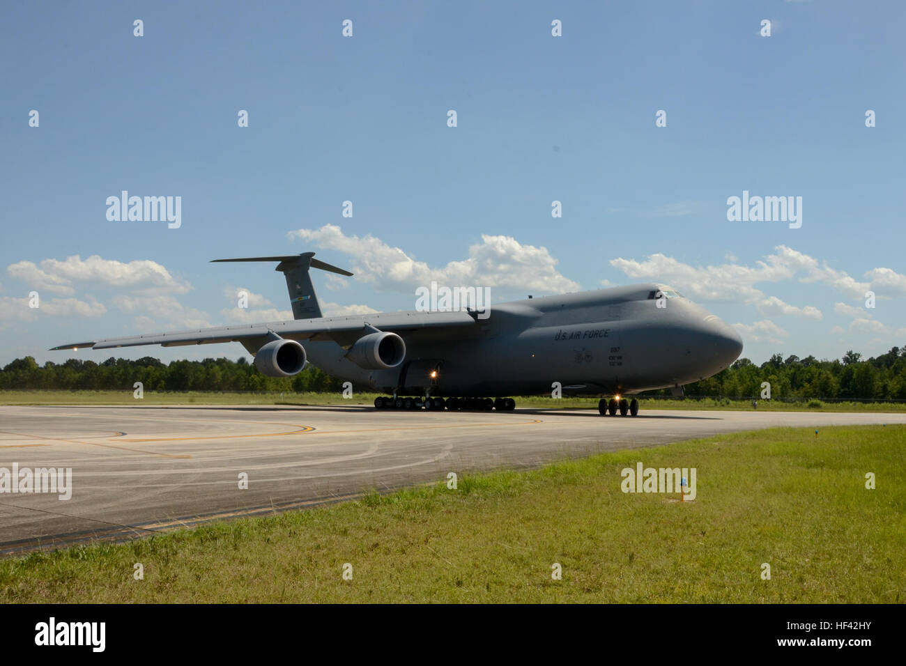 A U.S. Air Force Lockheed C-5 Galaxy transport aircraft taxis onto the runway at McEntire Joint National Guard Base, S.C., July 8, 2016. Approximately 300 U.S. Airmen and 12 F-16 Fighting Falcon jets from the 169th Fighter Wing at McEntire JNGB, S.C., are deploying to Osan Air Base, Republic of Korea, as the 157th Expeditionary Fighter Squadron in support of the U.S. Pacific Command Theater Security Package. (U.S. Air National Guard photo by Airman 1st Class Megan Floyd) SCANG TSP 747 Cargo Load 160708-Z-VD276-047 Stock Photo