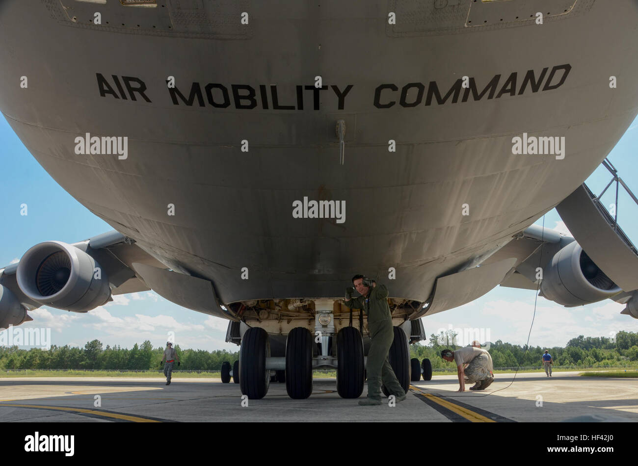 U.S. Air Force Tech. Sgt. Jake Schlemmer, a flight engineer assigned to the 709th Airlift Squadron, poses under a U.S. Air Force Lockheed C-5 Galaxy transport aircraft at McEntire Joint National Guard Base, S.C., July 8, 2016. Approximately 300 U.S. Airmen and 12 F-16 Fighting Falcon jets from the 169th Fighter Wing at McEntire JNGB, S.C., are deploying to Osan Air Base, Republic of Korea, as the 157th Expeditionary Fighter Squadron in support of the U.S. Pacific Command Theater Security Package. (U.S. Air National Guard photo by Airman 1st Class Megan Floyd) SCANG TSP 747 Cargo Load 160708-Z- Stock Photo