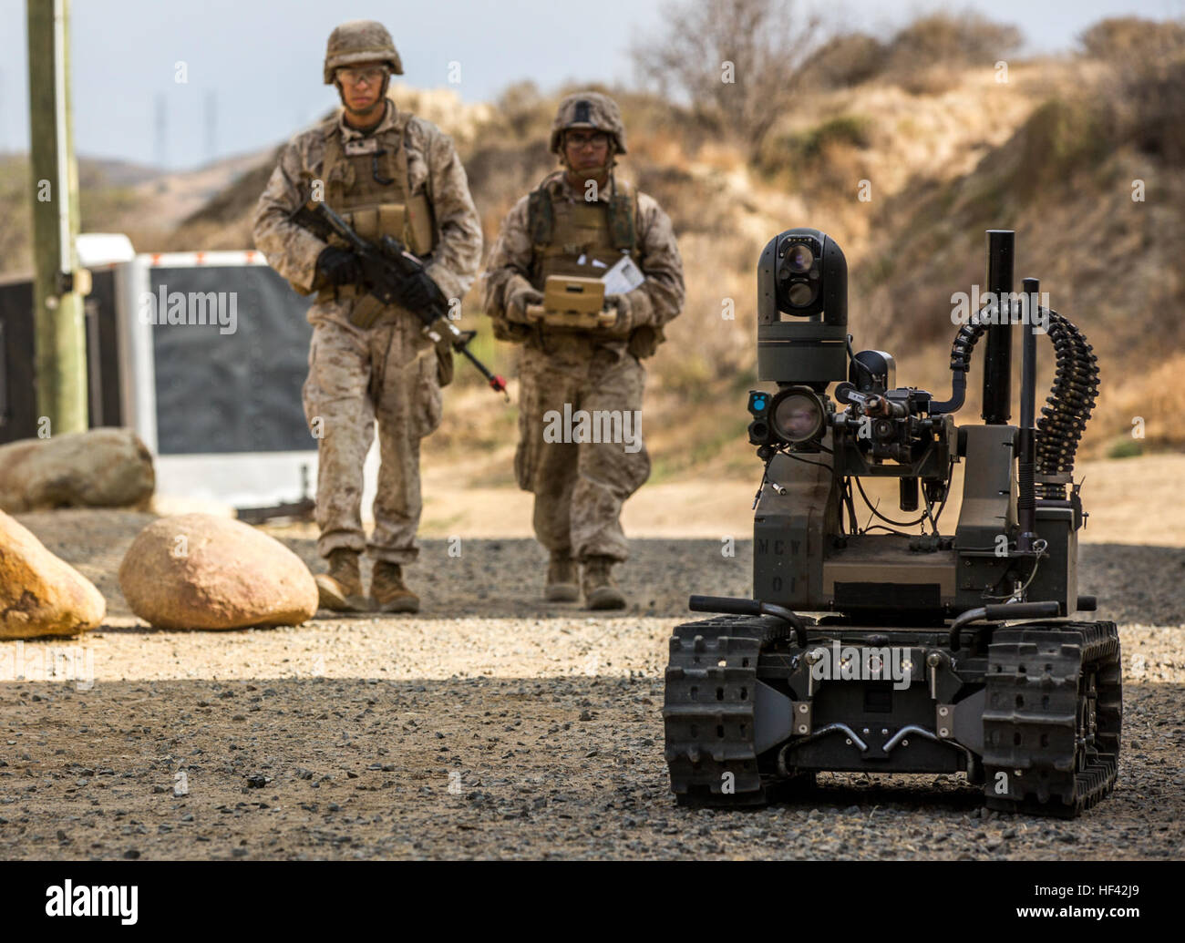 MARINE CORPS BASE CAMP PENDLETON, Calif. - U.S. Marines Pfc. Edgar Langle and Lance Cpl. Ricardo Talavera, both infantry Marines with Kilo Company, 3rd Battalion 5th Marine Regiment, conduct a foot patrol with the Modular Advanced Armed Robotic System during an exercise for Marine Corps Warfighting Laboratory's Marine Air-Ground Task Force Integrated Experiment on Camp Pendleton, Calif., July 9, 2016. The Warfighting Lab is conducting an experiment in conjunction with the Rim of the Pacific exercise to explore new gear and assess its capabilities for potential future use. The Warfighting Lab i Stock Photo