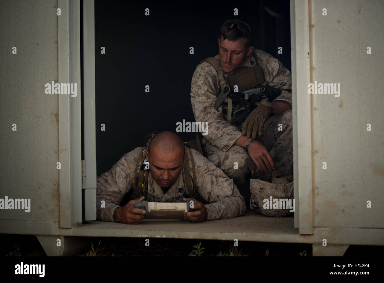 Staff Sgt. Dustin Decou and Sgt. Kevin Peach with 3rd Battalion, 5th Marine Regiment look for nearby threats through the camera of a “dragon fire” at Marine Corps Base Camp Pendleton, Calif., July 13, 2016. The system, meant to increase initial visibility of the enemy before the Marines need to engage them, was built by the Marine Corps Warfighting Laboratory. It can be tossed and kicked around, is invertible with front and rear cameras, and is both day and night capable. The lab is conducting a Marine Air-Ground Task Force Integrated Experiment in conjunction with Rim of the Pacific exercise  Stock Photo