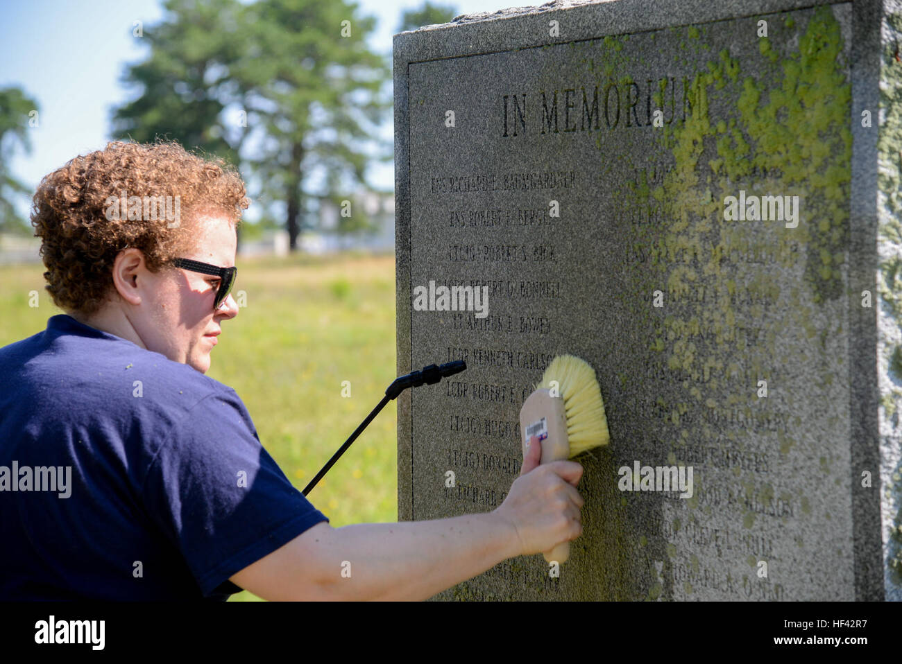 Melissa Swanson, Naval History and Heritage Command Conservator, uses a scrub brush to remove lichens growing on a U.S. Navy VC-4 memorial marker, located near the main gate of the 177th Fighter Wing of the New Jersey Air National Guard in Egg Harbor Township, N.J., on July 20, 2016. The monument, erected in May 1994 by the Association of The Composite Squadron Four Nightcappers, pays tribute to the members of the VC-4 Squadron based at Naval Air Station Atlantic City from September 1948 to May 1958 who gave the ultimate sacrifice. Swanson, based out of Richmond, Virginia, earned an undergradu Stock Photo