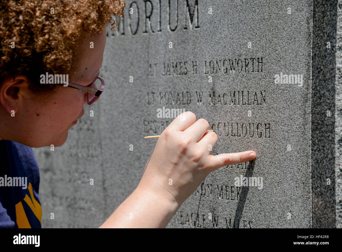 Melissa Swanson, Naval History and Heritage Command Conservator, uses a wooden pick to remove lichens growing inside the letters of inscriptions on a U.S. Navy VC-4 memorial marker, located near the main gate of the 177th Fighter Wing of the New Jersey Air National Guard in Egg Harbor Township, N.J., on July 20, 2016. The monument, erected in May 1994 by the Association of The Composite Squadron Four Nightcappers, pays tribute to the members of the VC-4 Squadron based at Naval Air Station Atlantic City from September 1948 to May 1958 who gave the ultimate sacrifice. Swanson, based out of Richm Stock Photo