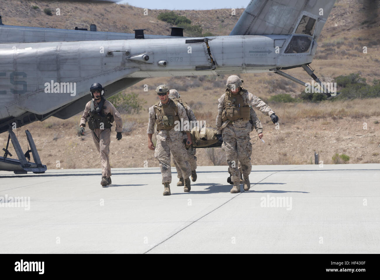 MARINE CORPS BASE CAMP PENDLETON, California (July 29, 2016) – U.S. Navy corpsmen from 1st Medical Battalion rush a casualty off an MV-22B Osprey after a simulated combat-related trauma at Marine Corps Air Ground Combat Center Twentynine Palms, California to a treatment facility at Camp Pendleton, July 29, 2016. Navy surgeons, doctors and nurses participated in the exercise during the Marine Corps Warfighting Lab Marine Air-Ground Task Force Integrated Experiment that will test the capabilities of new deployable medical equipment and the efficiency of using the least amount of supplies and per Stock Photo