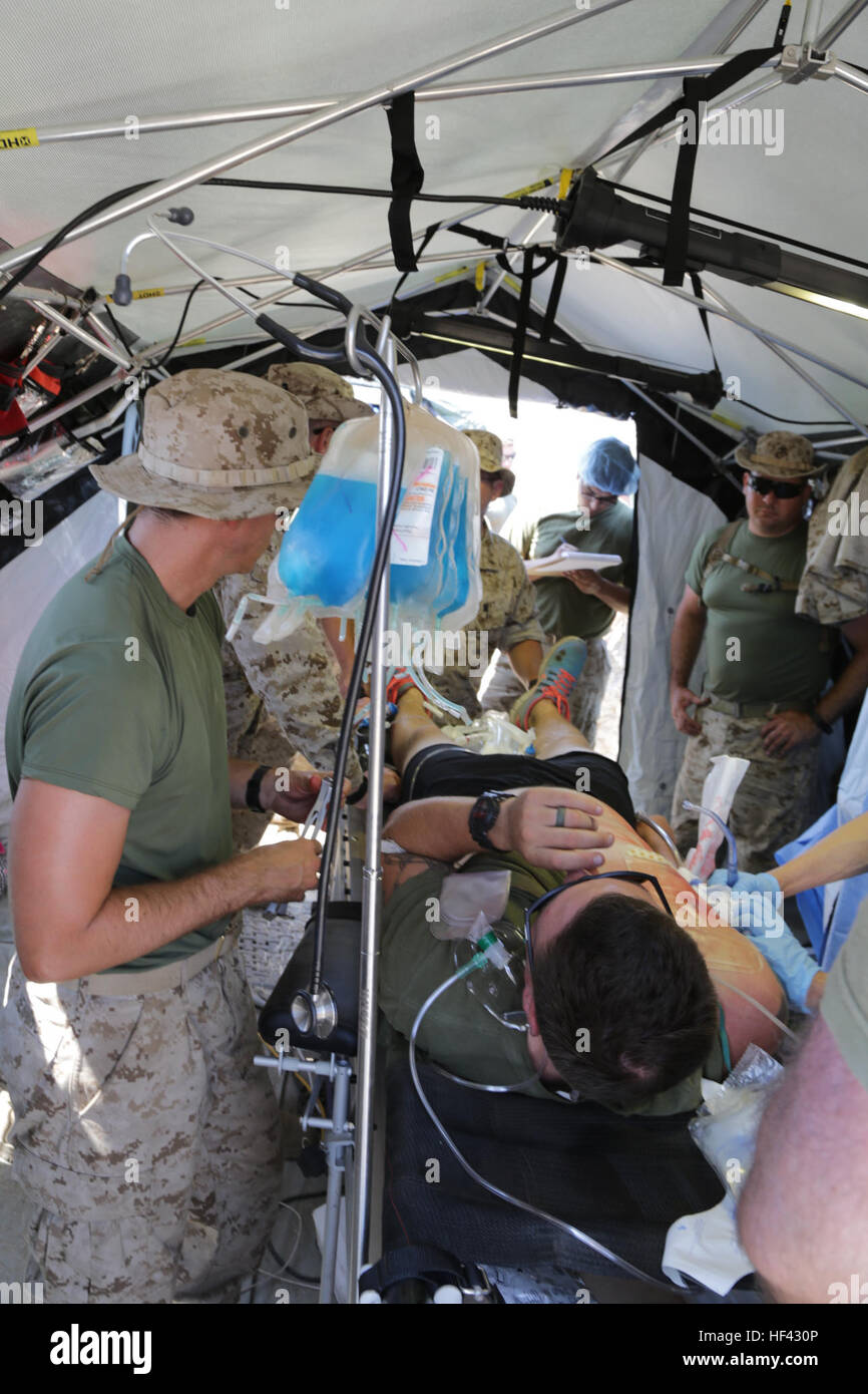 MARINE CORPS BASE CAMP PENDLETON, California (July 29, 2016) – U.S. Navy corpsmen from 1st Medical Battalion begin to operate on a victim of simulated combat-related trauma aboard Camp Pendleton July 29, 2016. Navy surgeons, doctors and nurses participated in the exercise during the Marine Corps Warfighting Lab Marine Air-Ground Task Force Integrated Experiment that will test the capabilities of new deployable medical equipment and the efficiency of using the least amount of supplies and personnel to achieve the most mobile and optimal care for damage control and resuscitative surgery in patie Stock Photo