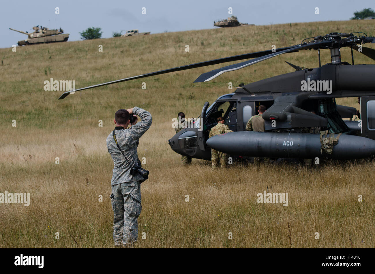 Spc. Timothy Jackson, a journalist with the 115th Mobile Public Affairs Detachment, Oregon Army National Guard, takes photos of a UH-60 Blackhawk with Company C, 3rd Battalion, 501st Aviation Regiment during Saber Guardian 2016 at the Romanian Land Forces Combat Training Center in Cincu, Romania, July 30. Saber Guardian 2016 is a multinational military exercise involving approximately 2,800 military personnel from ten nations including Armenia, Azerbaijan, Bulgaria, Canada, Georgia, Moldova, Poland, Romania, Ukraine and the U.S. The objectives of this exercise are to build multinational, regio Stock Photo