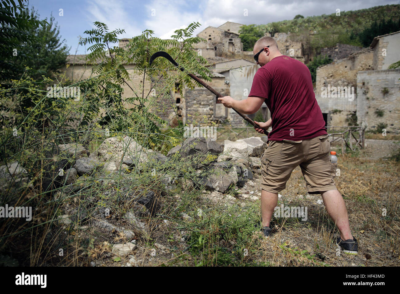 RPSA Alexander Varner, religious personnel with Special Purpose Marine Air-Ground Task Force Crisis Response-Africa, cuts down weeds and overgrowth with a sickle in Vizzini, Sicily, Sept. 7, 2016.  Marines volunteered to clean up a local historic site and build fences during a community relations project.  (U.S. Marine Corps photo by Cpl. Alexander Mitchell/released) Marines restore historic Italian site 160907-M-ML847-531 Stock Photo