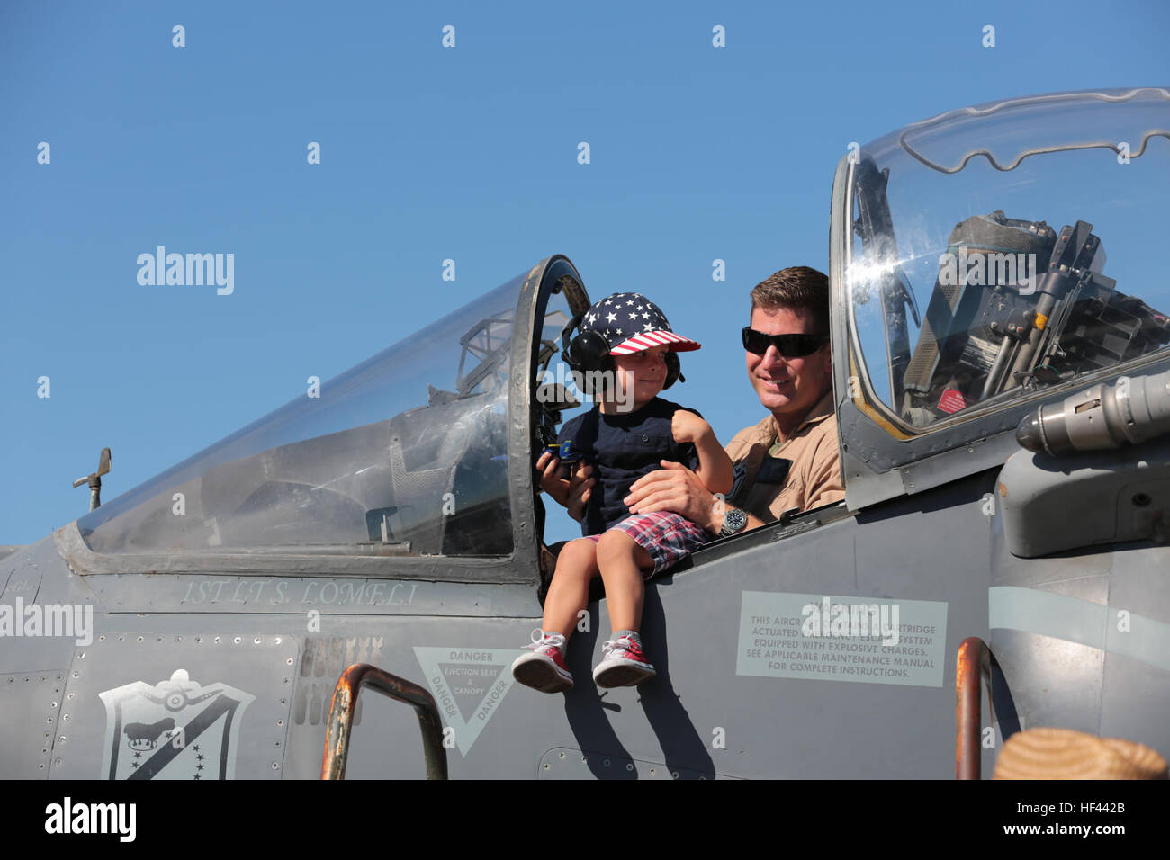 A U.S. Marine poses with a child in the cockpit of an AV-8B Harrier during the 2016 Marine Corps Air Station (MCAS) Miramar Air Show at MCAS Miramar, Calif., Sept. 24, 2016. The MCAS Miramar Air Show honors 100 years of the Marine Corps Reserves by showcasing aerial prowess of the Armed Forces and their appreciation of civilian community’s support to the troops. (U.S. Marine Corps photo by Pfc. Nadia J. Stark/Not Released) 2016 MCAS Miramar Air Show 160924-M-BV291-251 Stock Photo