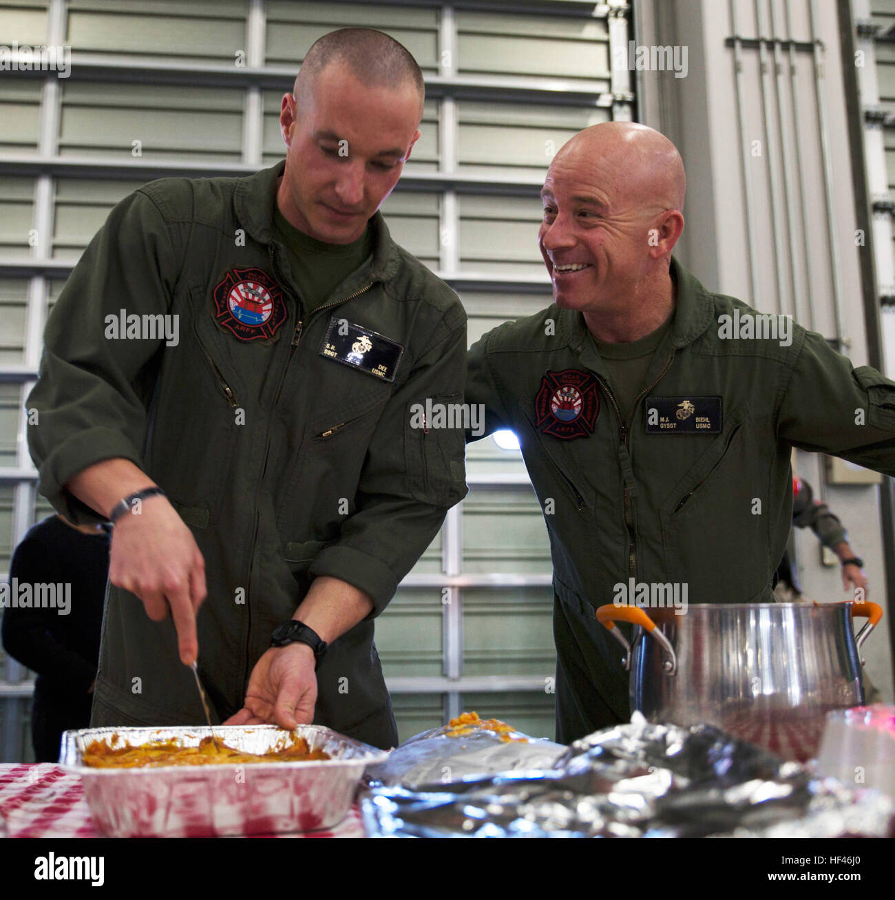 U.S. Marine Corps Staff Sgt. Sean Dee, left, the Aircraft Rescue and Firefighting station captain, and Gunnery Sgt. Matthew Viehl, assistant chief of operations at ARFF, prepare to serve food for the ARFF Tsuta Orphanage Christmas party at Marine Corps Air Station Iwakuni, Japan, Dec. 10, 2016. ARFF holds the party annually to help spread Christmas cheer to the orphans and to bring service members, their families and the Japanese together. Marines volunteered their time and provided the children with a homemade, American meal. (U.S. Marine Corps photo by Lance Cpl. Gabriela Garcia-Herrera) Air Stock Photo