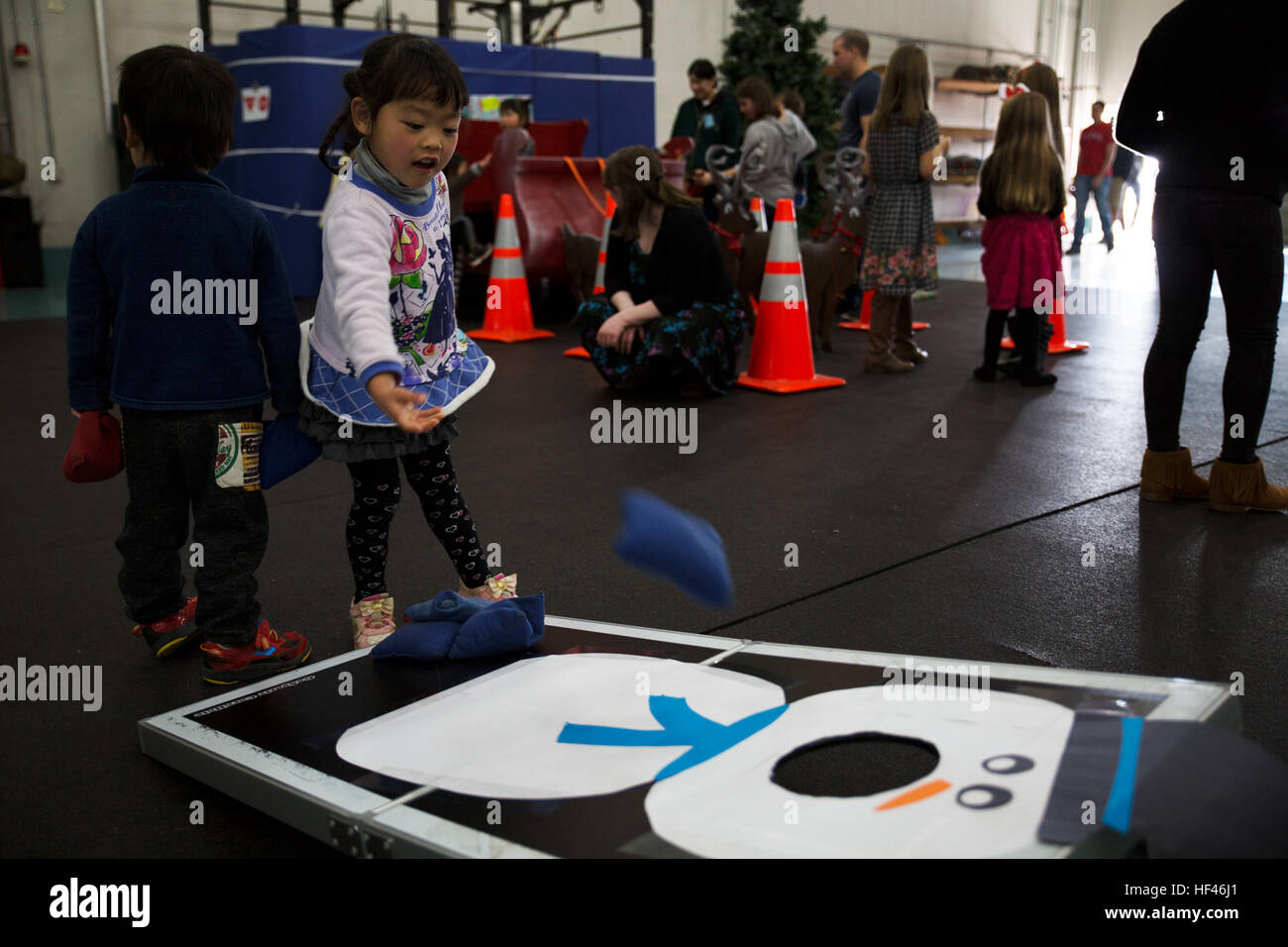 Cocona, a child from ARFF Tsuta Orphanage, plays corn hole during the ARFF Tsuta Christmas party at Marine Corps Air Station Iwakuni, Japan, Dec. 10, 2016. ARFF holds the event annually to help spread Christmas cheer to the orphans and to bring service members, their families and the Japanese together. Activities such as a bouncy house, Christmas cookie decorating and games were available to the children during the event. (U.S. Marine Corps photo by Lance Cpl. Gabriela Garcia-Herrera) Aircraft Rescue and Firefighting Marines bring Christmas to orphans 161210-M-NE059-0042 Stock Photo