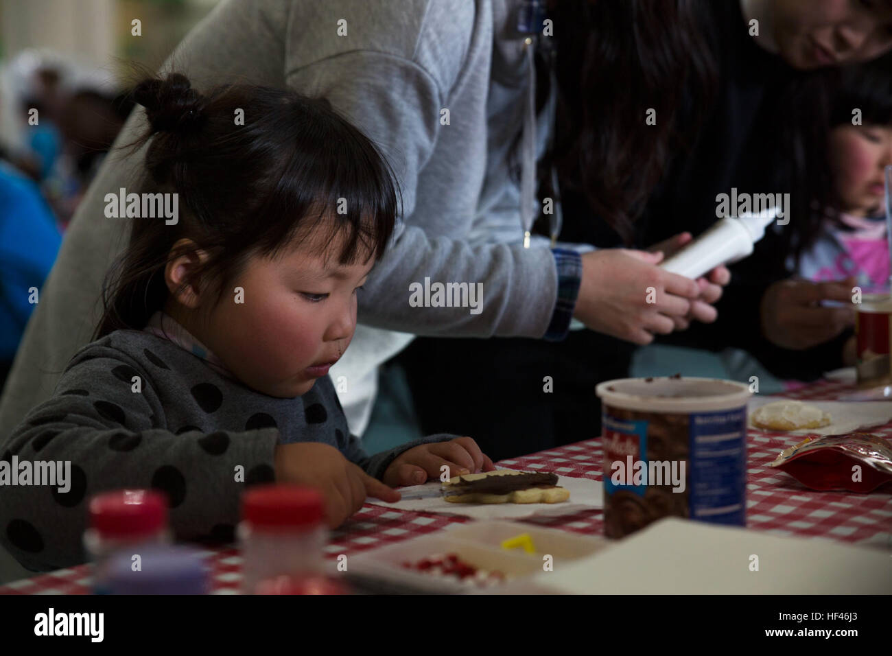 May Yamane, a child from the local orphanage, decorates Christmas cookies at the ARFF Tsuta Orphanage Christmas party at Marine Corps Air Station Iwakuni, Japan, Dec. 10, 2016. ARFF holds the celebration annually to help spread holiday cheer to the orphans and to bring service members, their families and Japanese together. Activities such as a bouncy house, Christmas cookie decorating, and games were available to the children during the party. (U.S. Marine Corps photo by Lance Cpl. Gabriela Garcia-Herrera) Aircraft Rescue and Firefighting Marines bring Christmas to orphans 161210-M-NE059-0127 Stock Photo