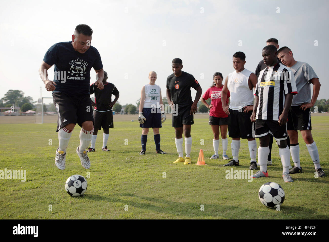 Marine Corps Staff Sgt. Jose Pena (left), a warehouse chief with 2nd Maintenance Battalion, 2nd Marine Logistics Group, demonstrates a conditioning drill to teammates at soccer practice at Camp Lejeune, N.C., July 7, 2010. Pena has been playing top-tier soccer for the Marine Corps' sports programs since 1998, including a stint on the 2009 All-Marine Soccer Team. (U.S. Marine Corps photo by Sgt. Jeremy Ross) Marine Recalls Top-Tier Soccer Career DVIDS303841 Stock Photo