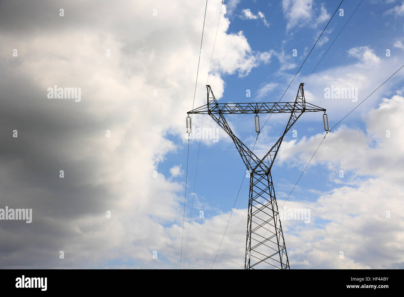 high voltage electric pylon against cloudy blue sky Stock Photo - Alamy