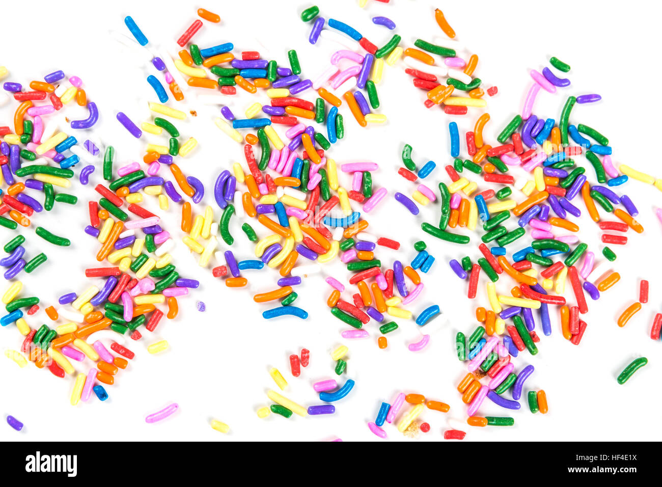 Assorted rainbow colored sprinkles isolated on white background Stock