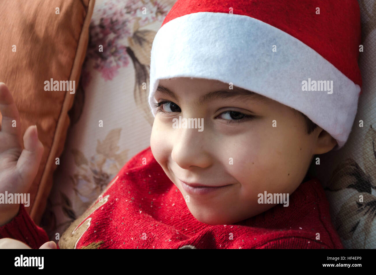A portrait of a young boy wearing a Father Christmas hat. Stock Photo