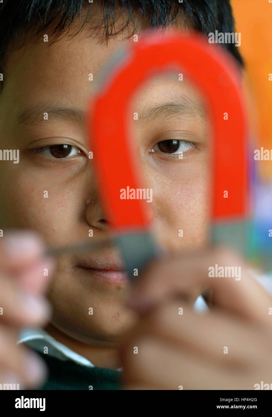 Student Using Magnet Students in a science class exploring magnetism with magnets and metal ...