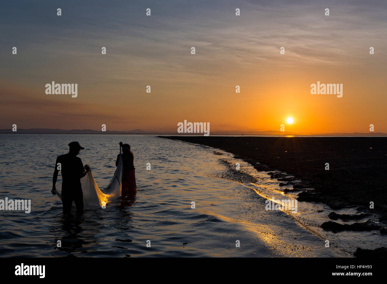 Ometepe Island, Nicaragua - April 7, 2014: Two fisherman fishing in the shores of the Ometepe Island in Lake Nicaragua, Nicaragua, at sunset Stock Photo