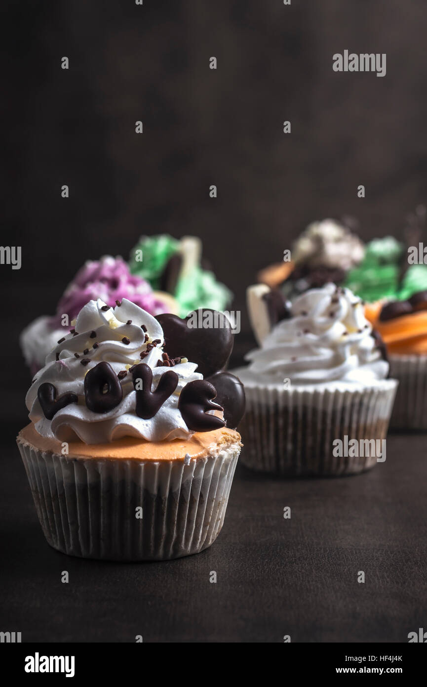 Chocolate cupcakes with cream on dark wooden background Stock Photo