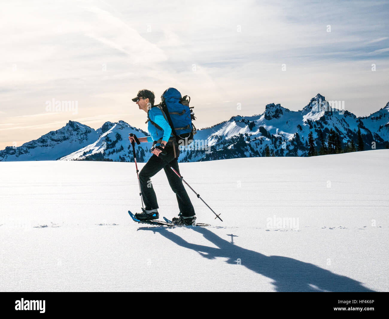 An older woman snowshoeing in the North Cascade mountains, Washington State Stock Photo