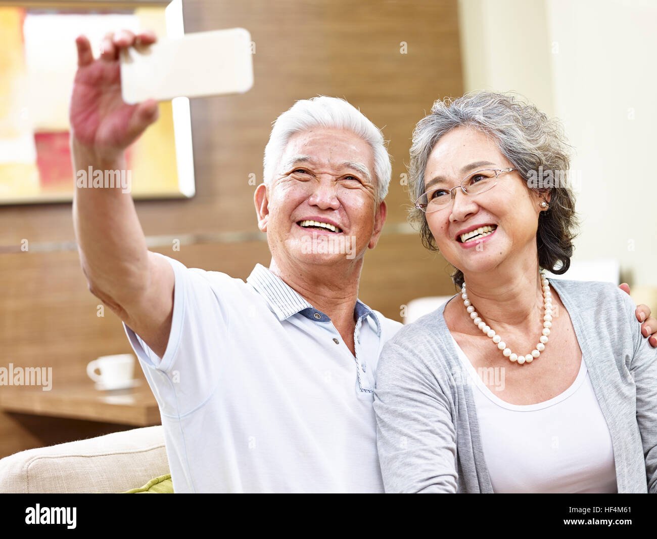 happy asian senior couple taking a selfie using mobile phone Stock ...