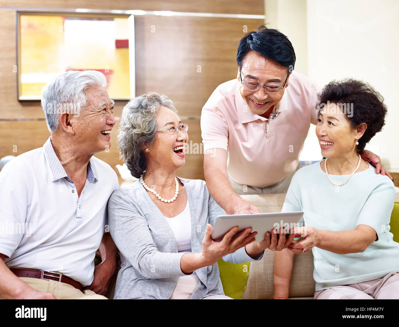 senior asian couples having a good time using tablet computer together. Stock Photo