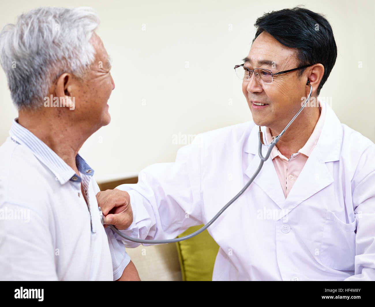 asian doctor checking senior patient using a stethoscope. Stock Photo