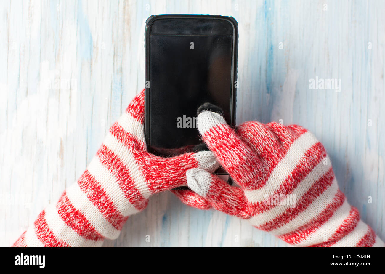 Hands using smart phone in winter gloves Stock Photo Alamy