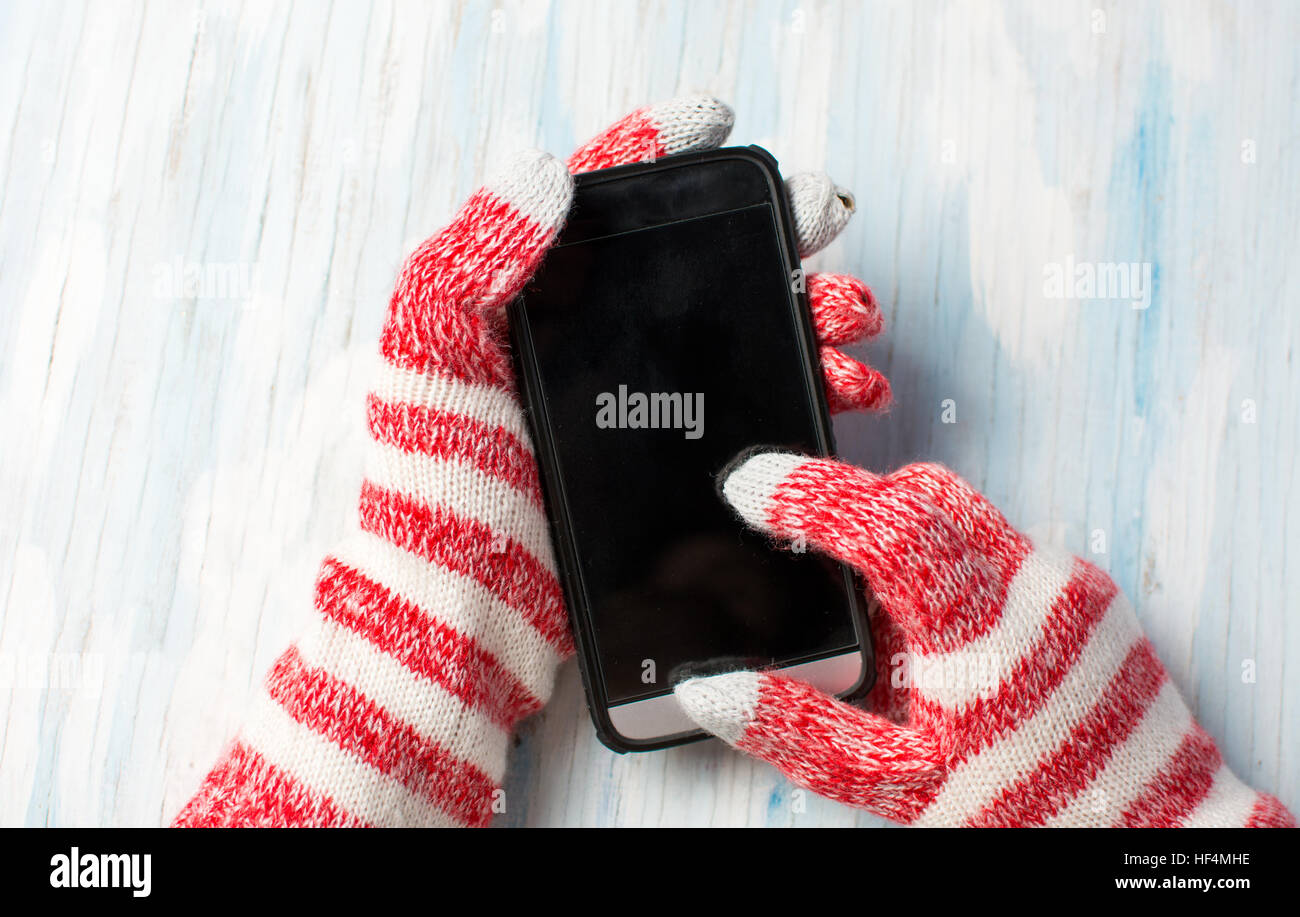 Hands using smart phone in winter gloves Stock Photo