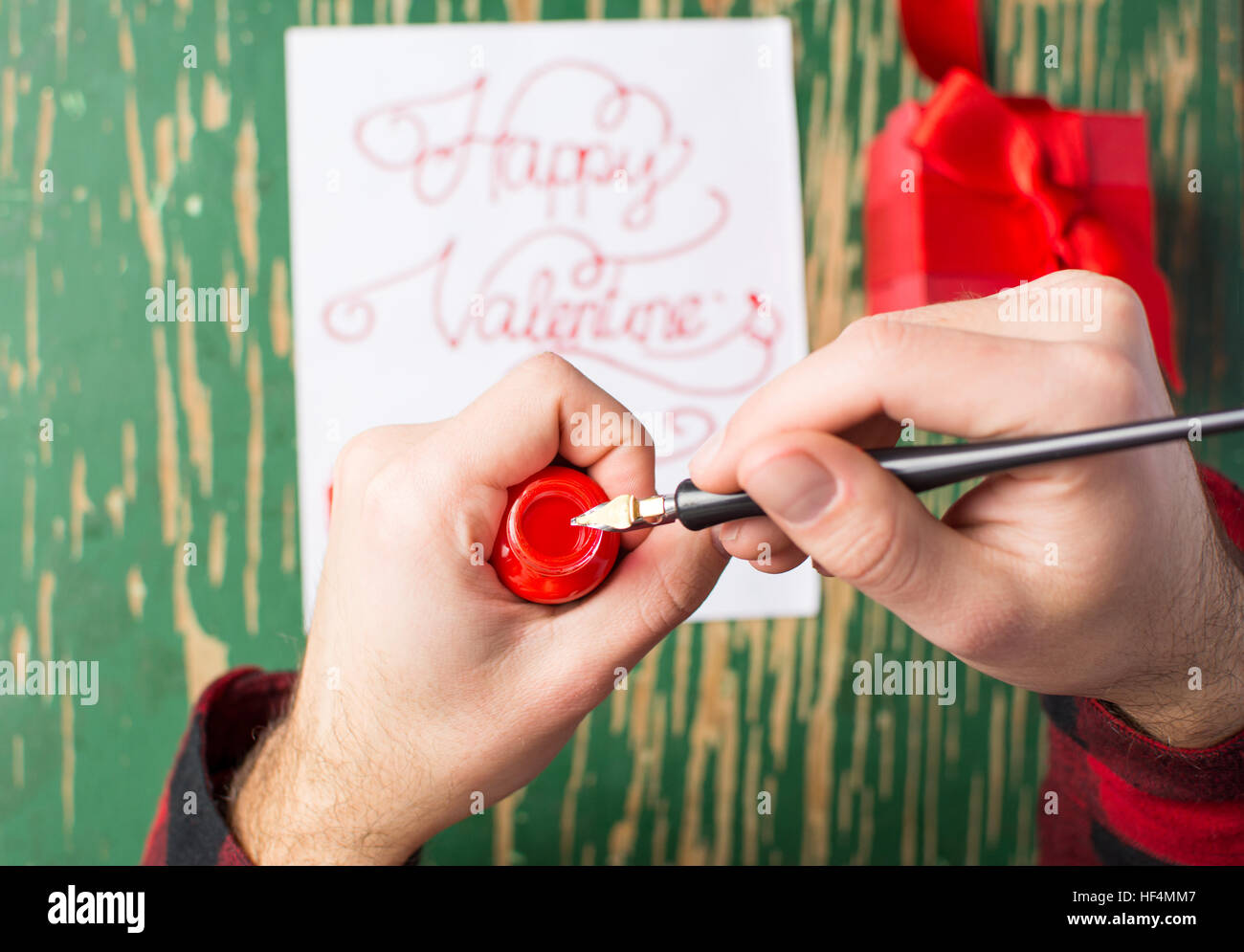 Male hands writing a calligraphy Valentines day card Stock Photo