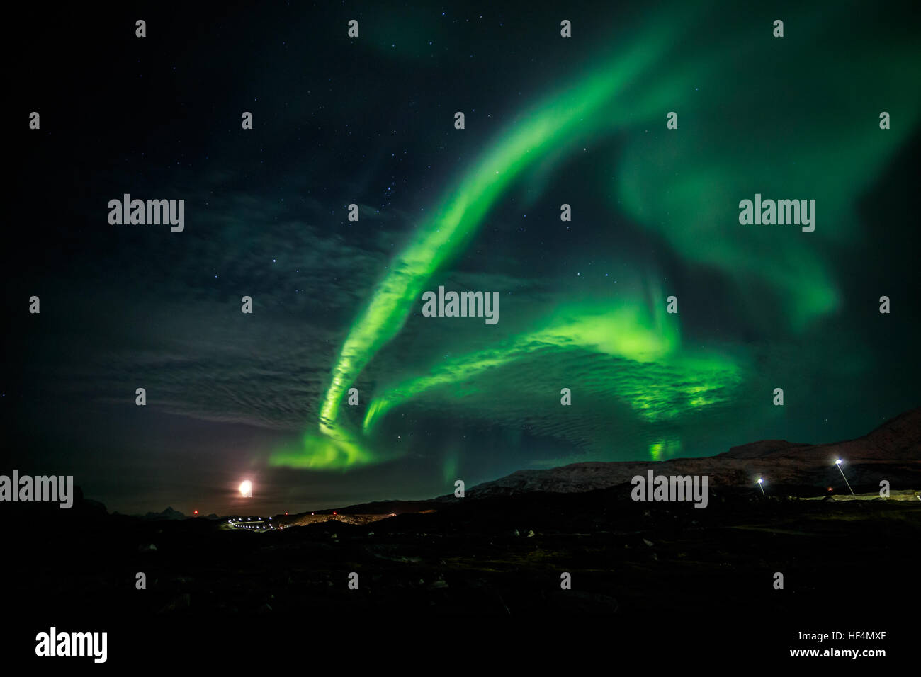 Northern lights and the rising Moon nearby Nuuk city, Greenland Stock Photo
