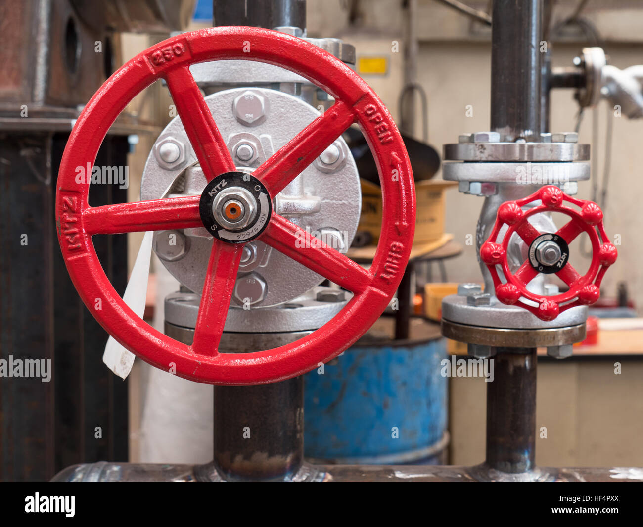 Two valves in industrial setting. Shallow depth of field with the nearest valve in focus. Stock Photo