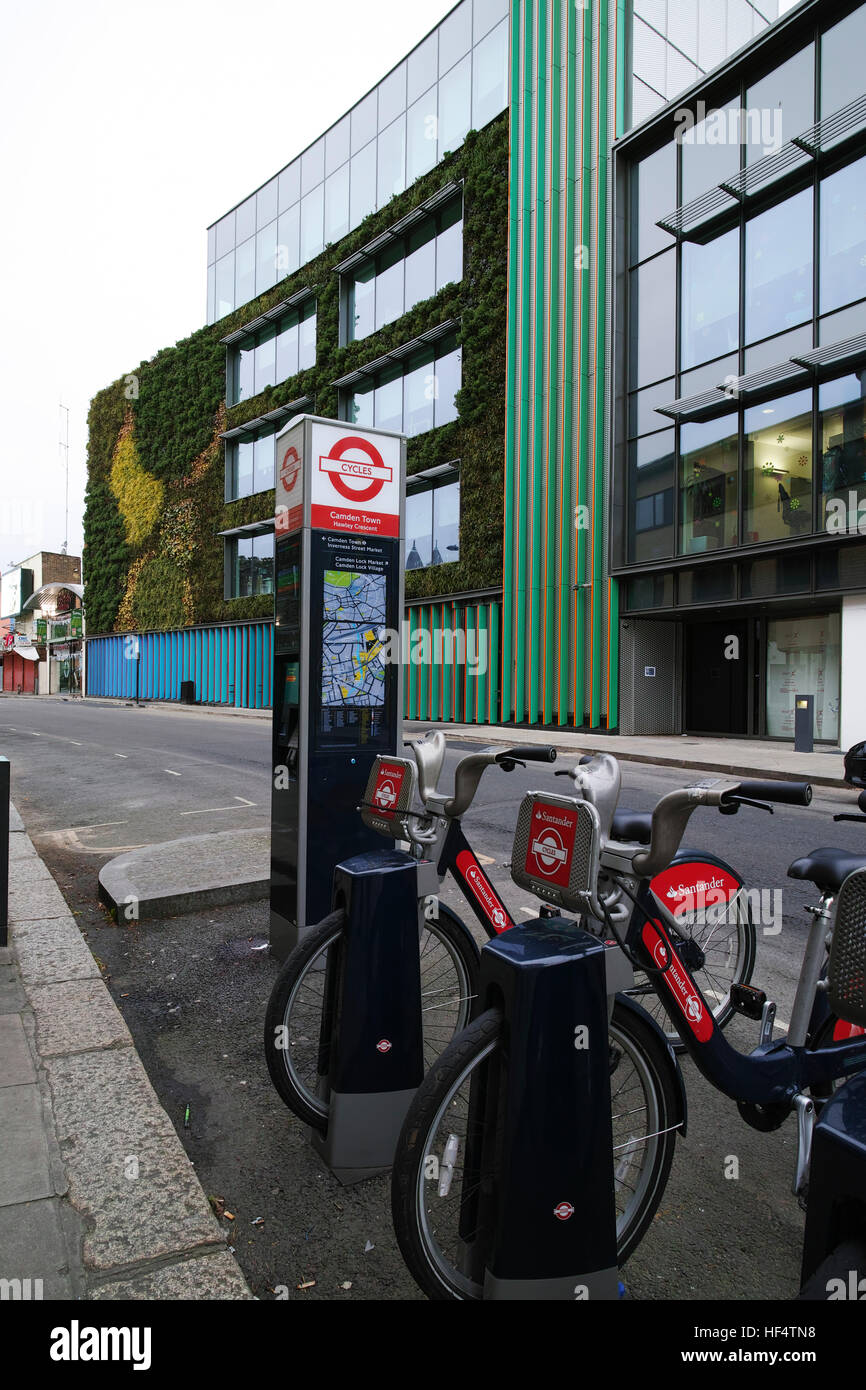 Boris Bikes and MTV Studio in Hawley Crescent Camden Town showing recently completed living wall in the background Stock Photo