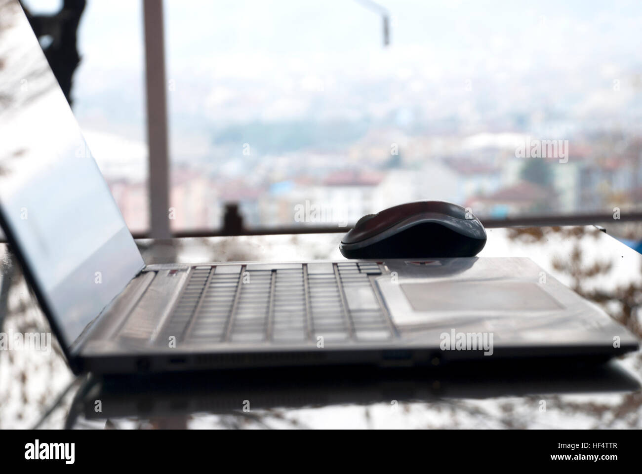 Laptop computer on a glass table at the window. Stock Photo